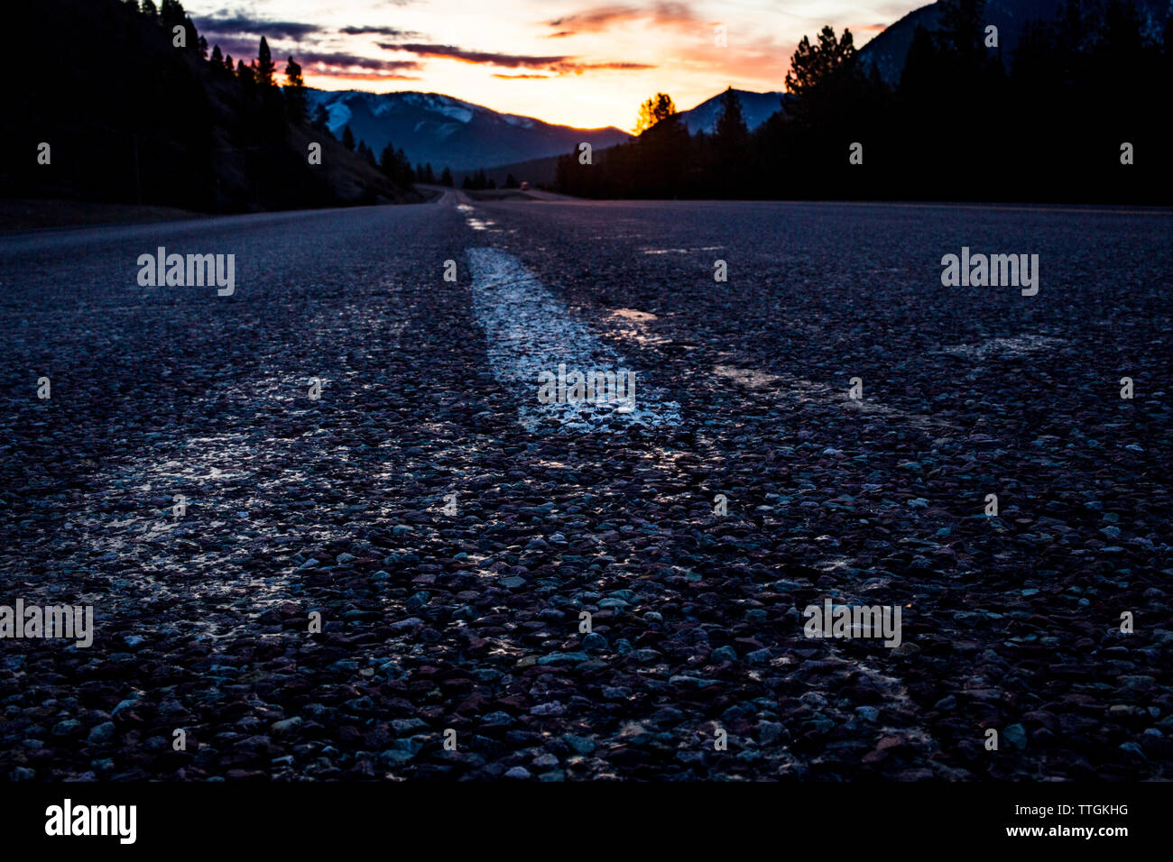 The sun rises above a vacant road (Interstate 90) in Montana Stock Photo