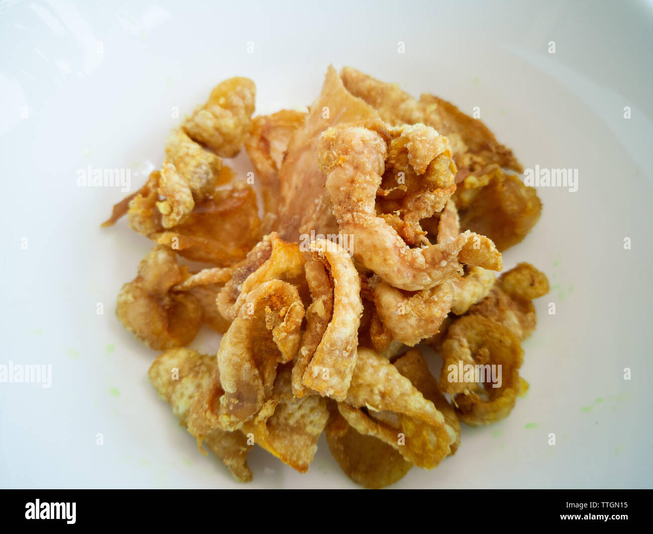 Close up of deep-fried chicken skins in a white bowl. Stock Photo