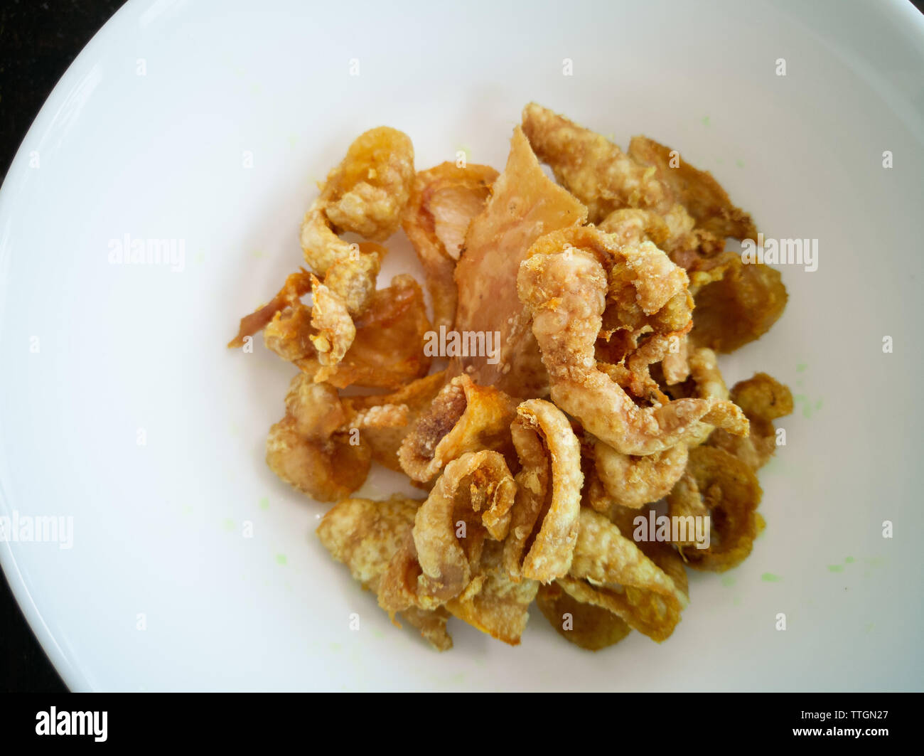 Close up of deepfried chicken skins in a white bowl Stock Photo Alamy