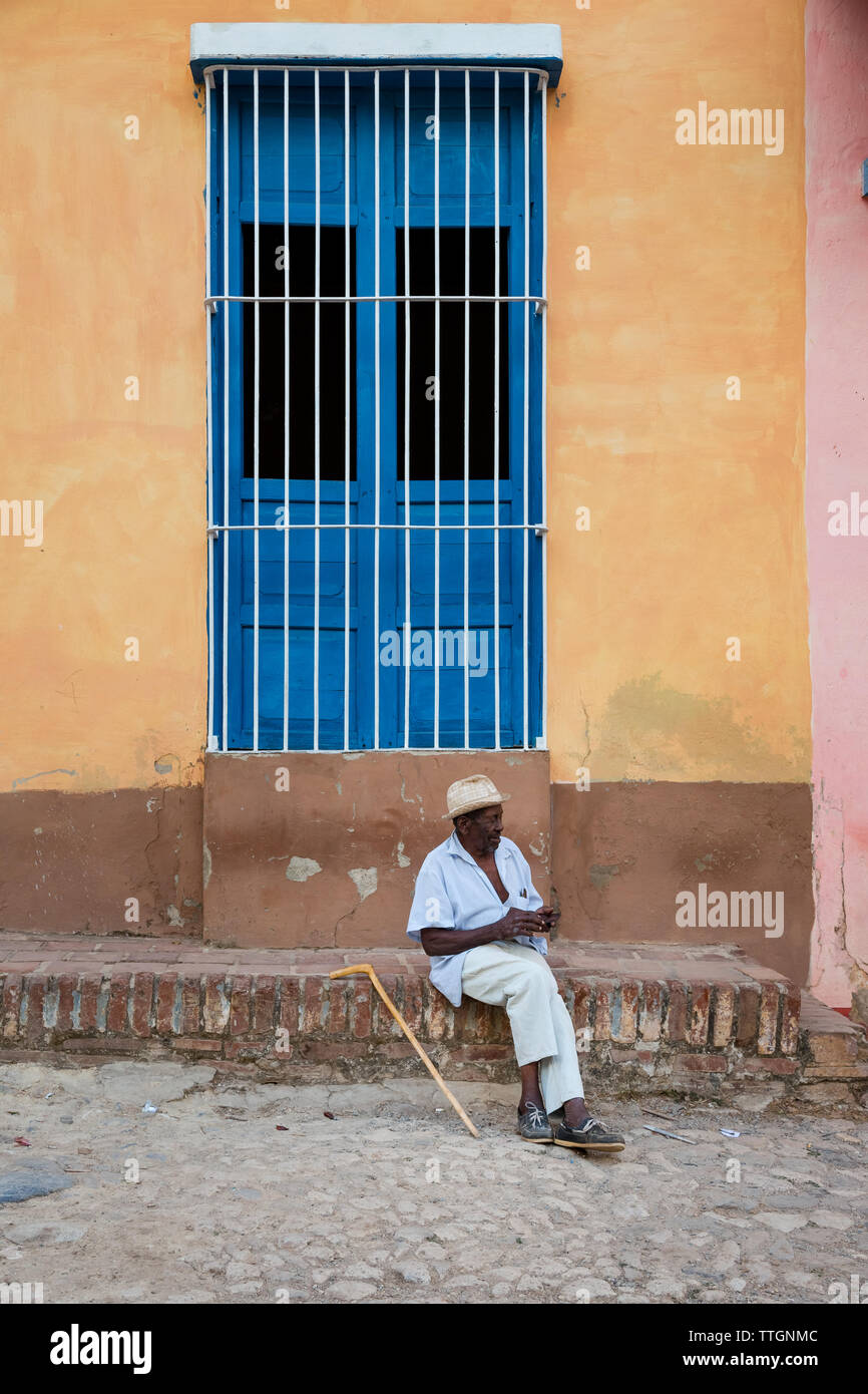 Cuban senior sitting outdoor. Real Life in Trinidad, Cuba 2017 Stock Photo