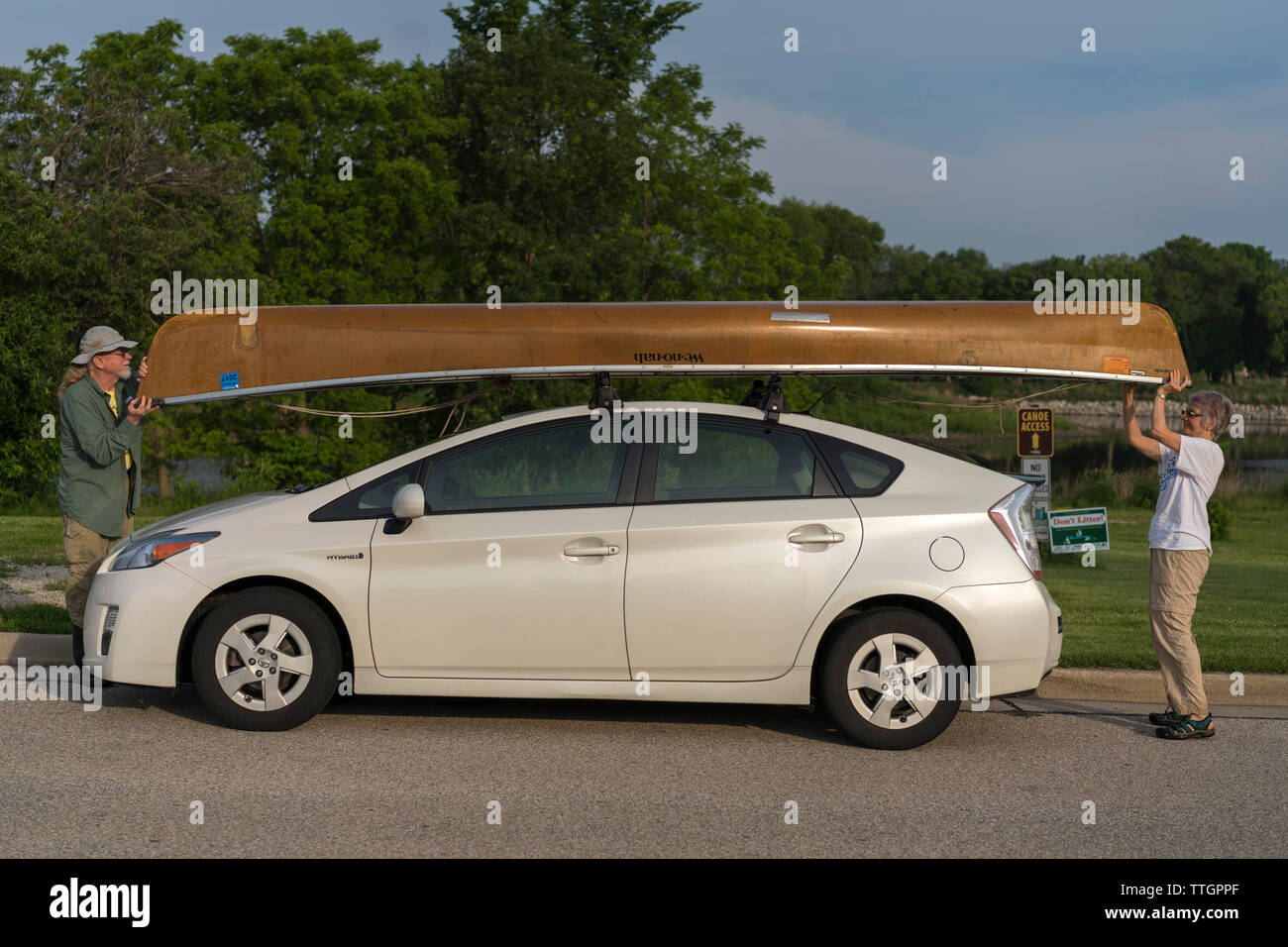 Couple puts a Canoe on Their Prius after boating the Milwaukee River Stock Photo