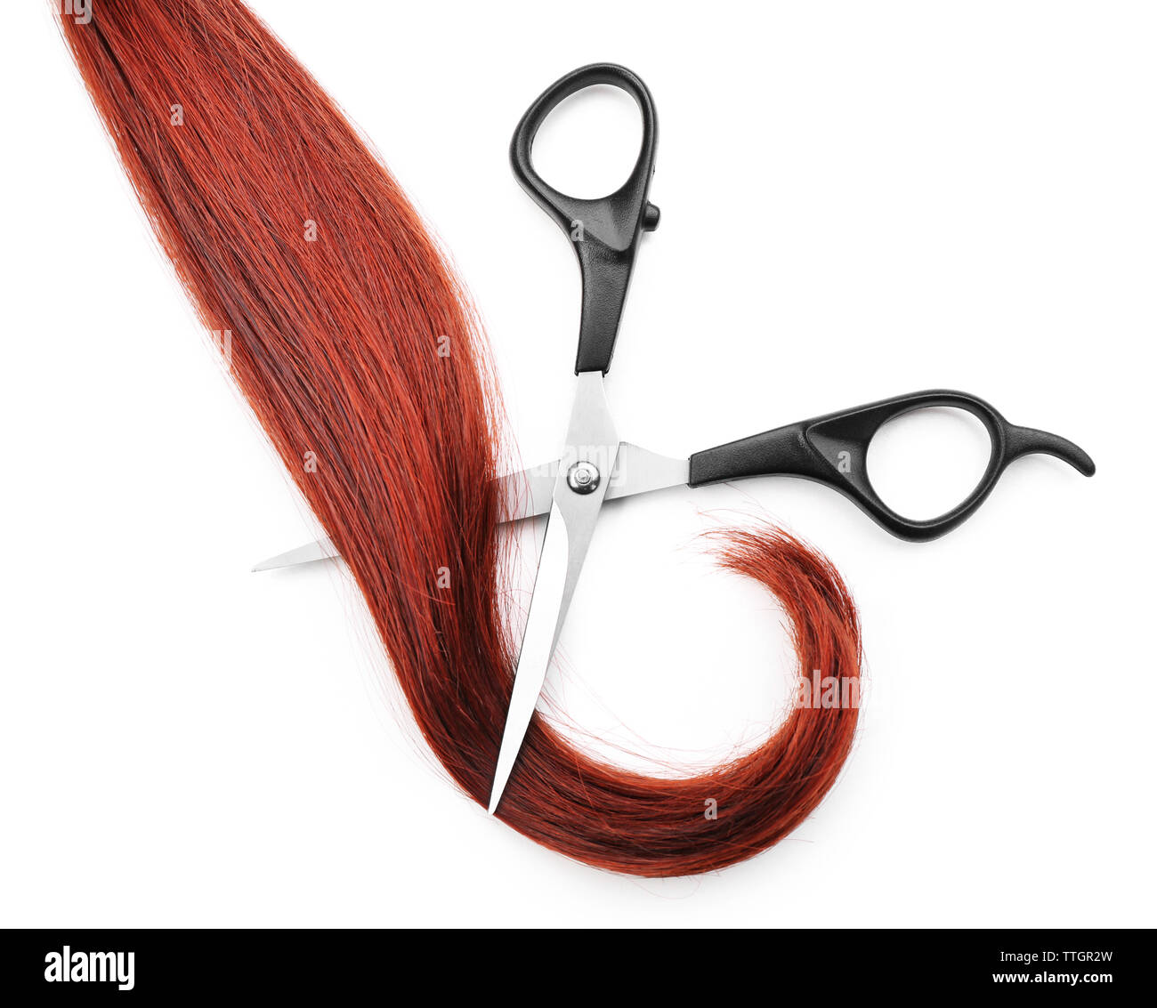 Hairdresser's scissors with strand of red hair, isolated on white Stock Photo