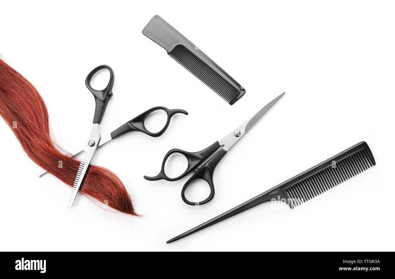 Hairdresser's scissors with combs, strand of red hair, isolated on white Stock Photo