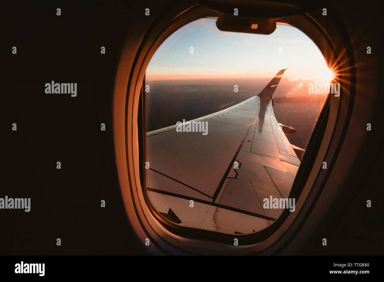 Sunset over California from the window seat of a plane with a sun star Stock Photo