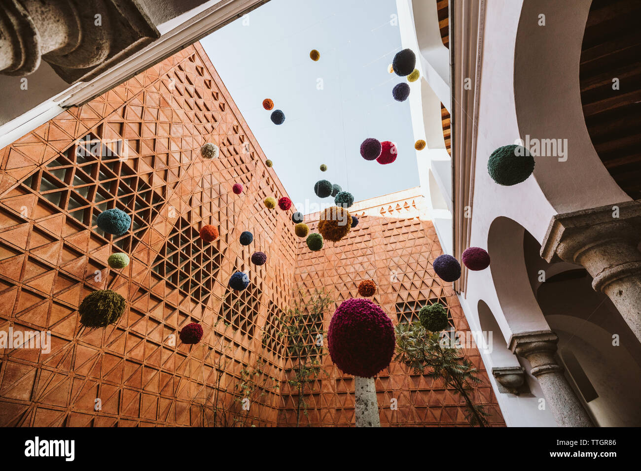 art installation of hanging colored yarn balls in historic oaxaca Stock Photo