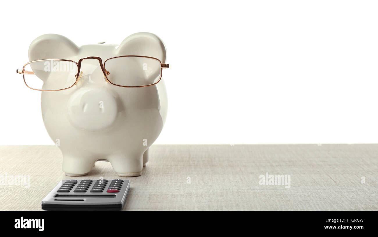Piggy bank with glasses and calculator on white background Stock Photo ...