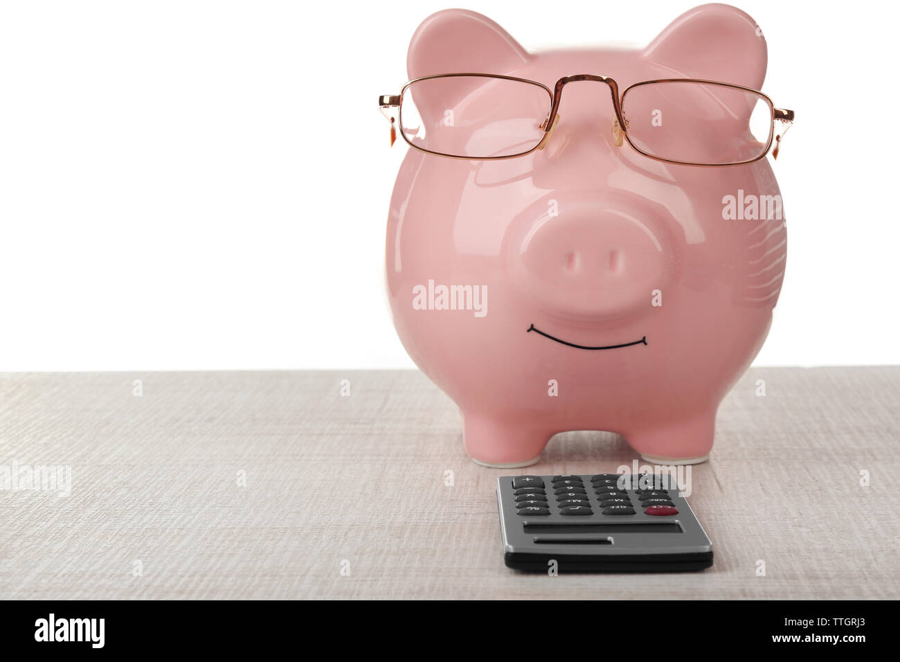 Pink piggy bank with glasses and calculator on white background Stock ...