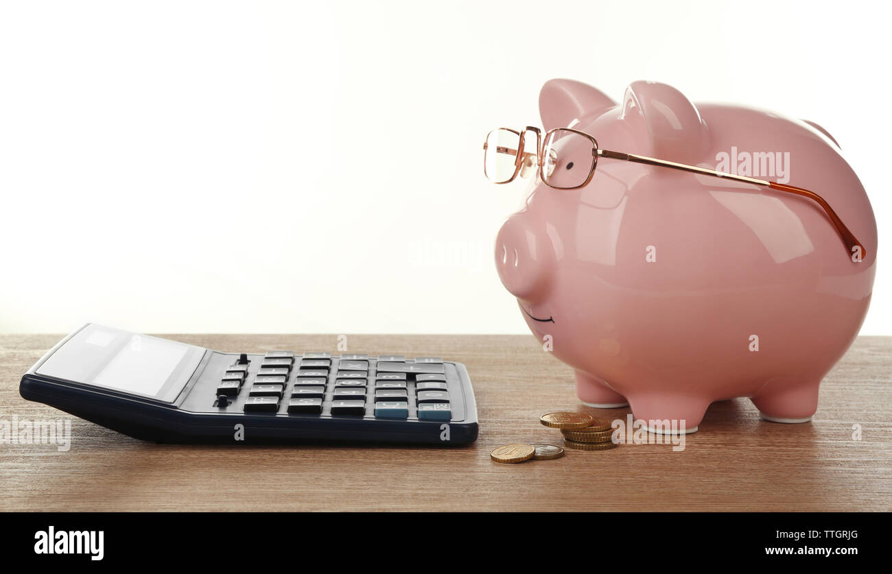 Pink piggy bank with glasses and calculator on white background Stock ...