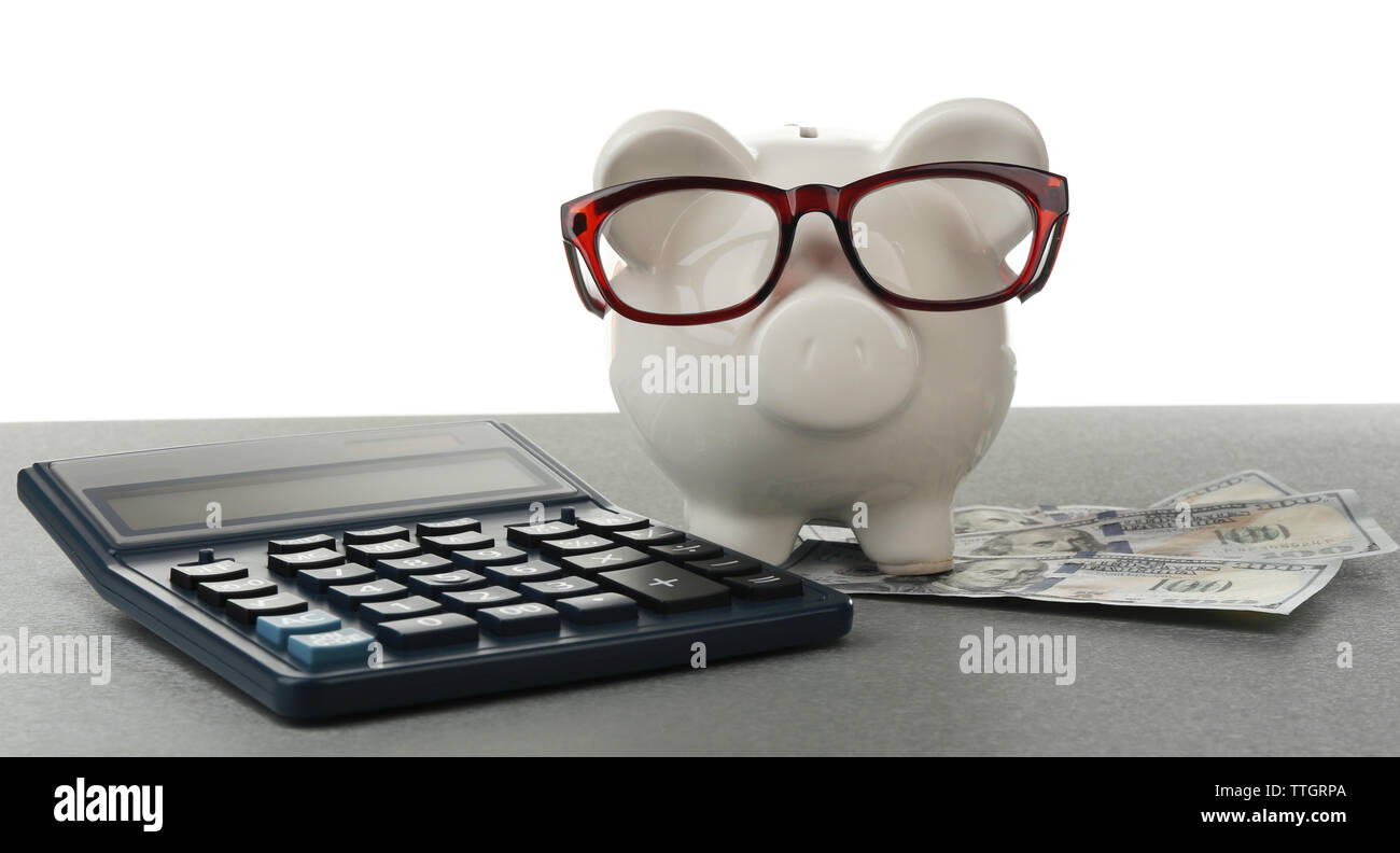 Piggy bank with dollar banknotes, glasses and calculator on white ...