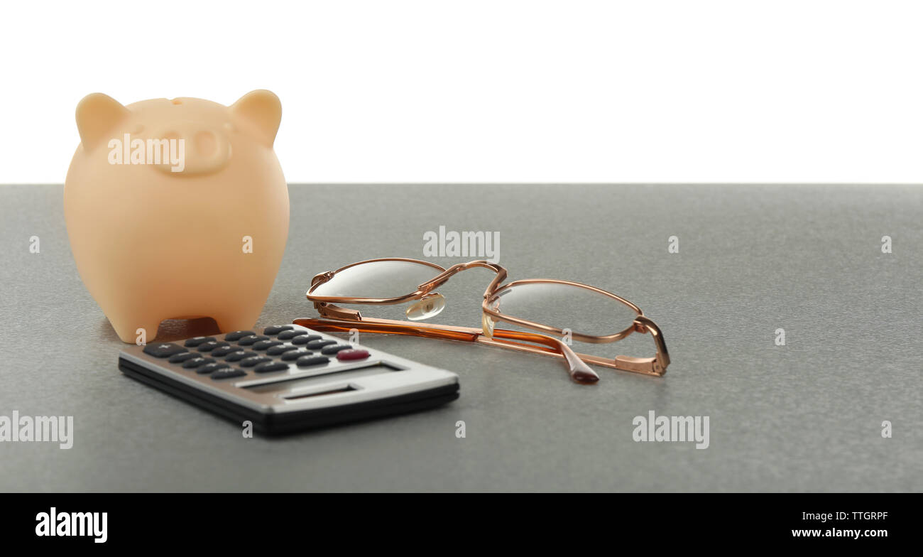 Beige piggy bank with glasses and calculator on white background Stock ...