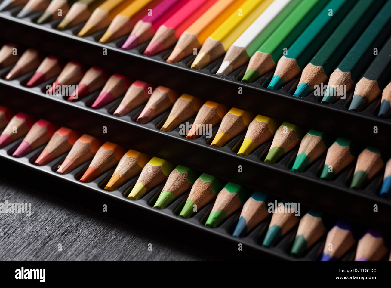 Watercolor pencils lined up in a black plastic box. Stock Photo
