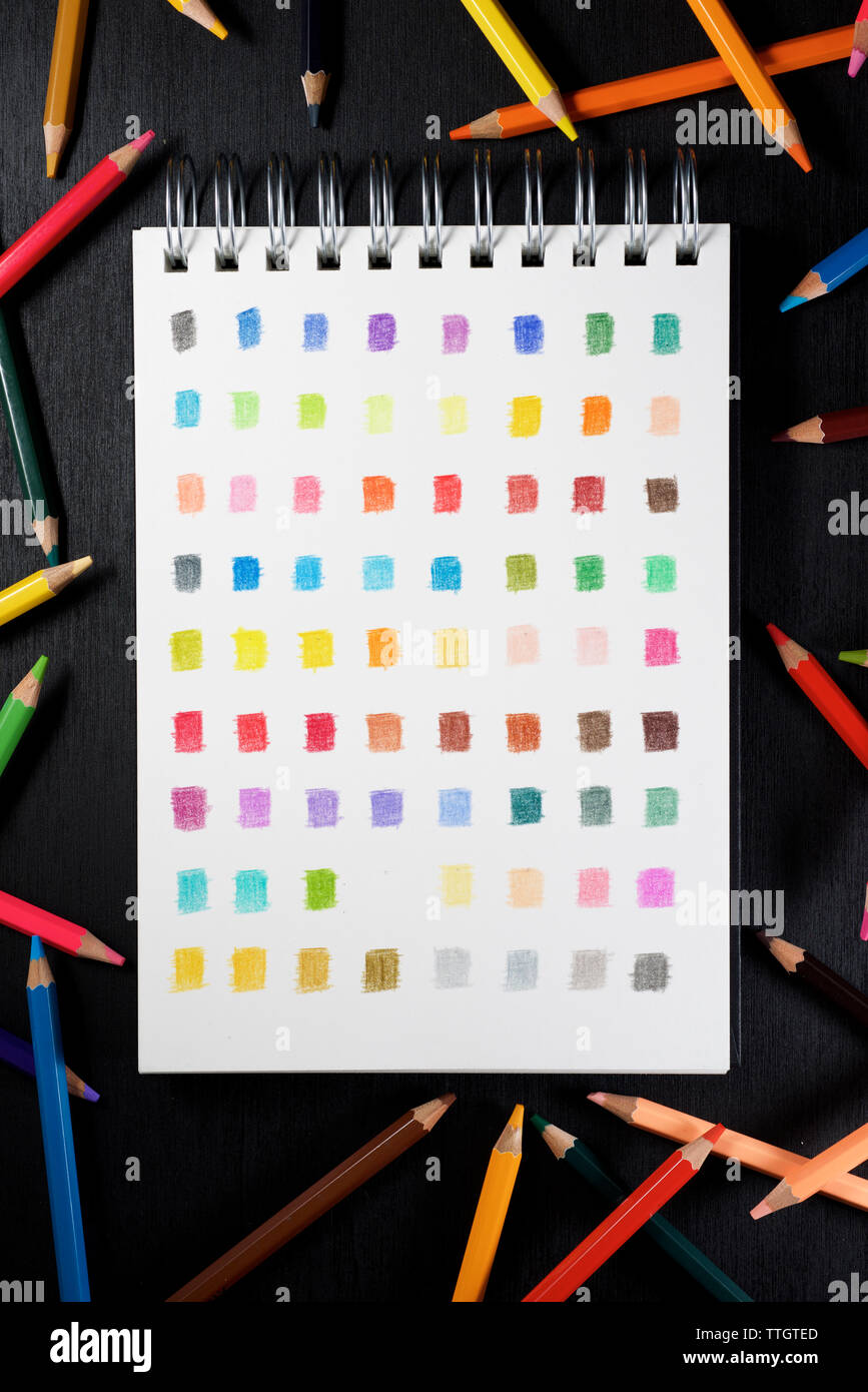 Palette of colors in a sketchbook and colored watercolor pencils Stock