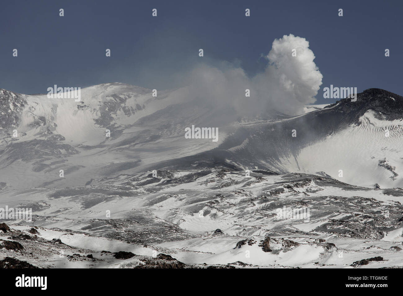 Volcan Copahue spews smoke and ash on a sunny winter day in Argentina. Stock Photo