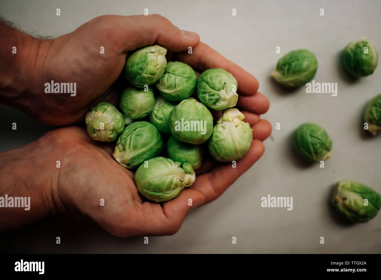 brussel sprouts in chefs hands on chopping board Stock Photo Alamy