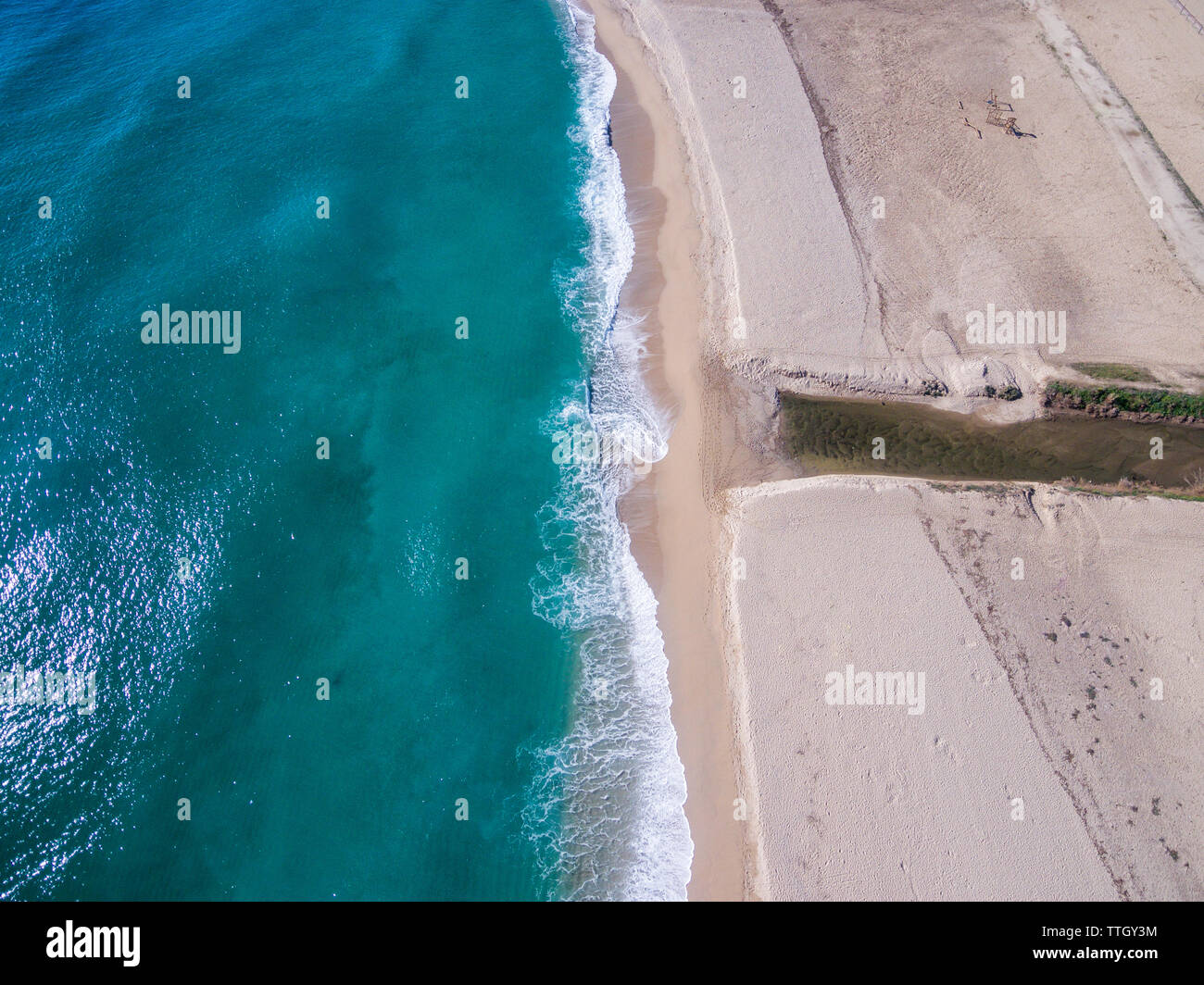 Waves rolling onto sandy beach Stock Photo