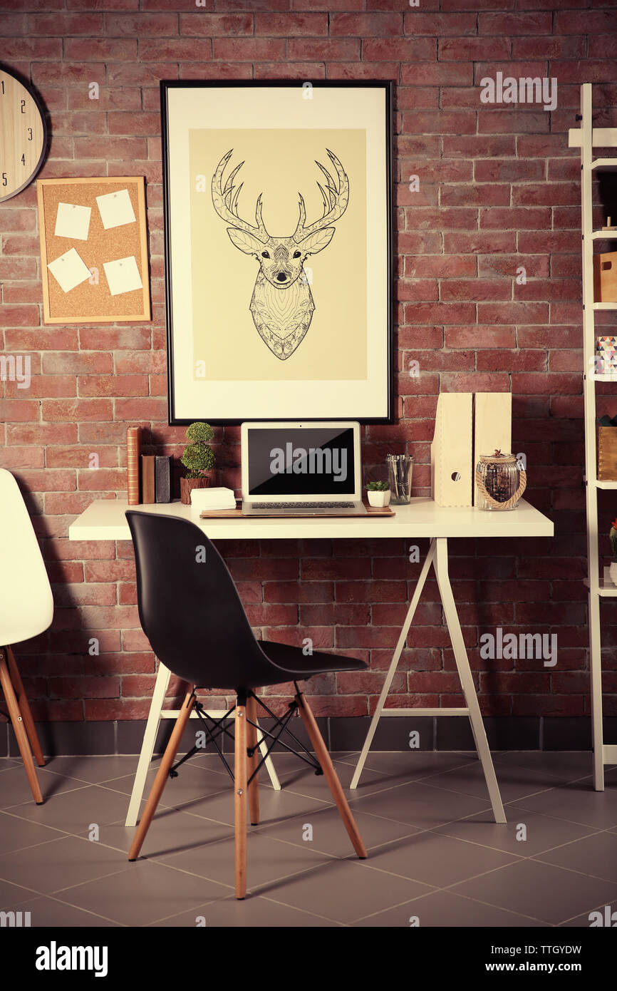 Workplace with laptop, table and bookcase brick wall background Stock Photo Alamy