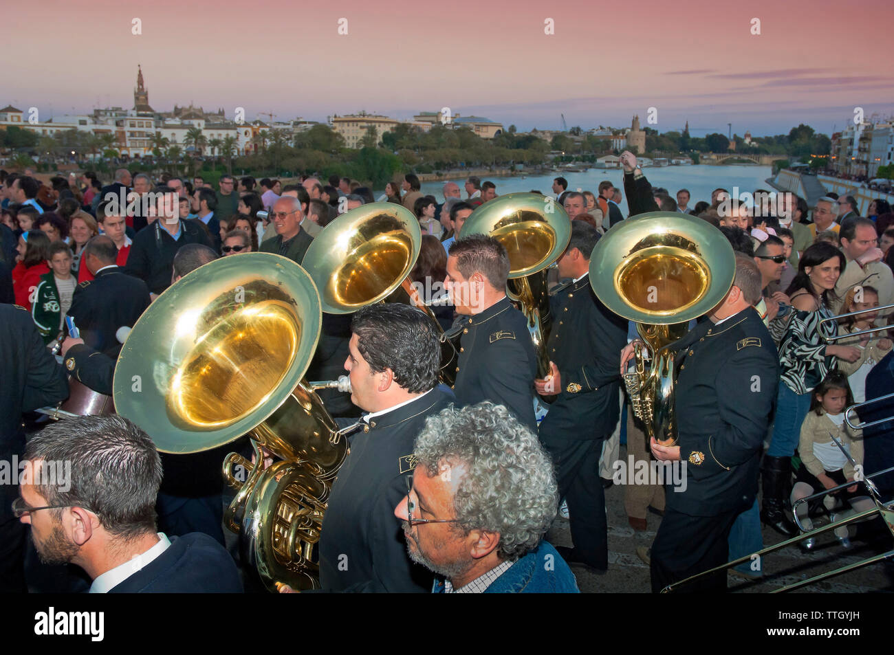 Holy Week. Brotherhood of La O. Music band procession on the bridge of Triana (in the background the river Guadalquivir and the city). Seville. Region Stock Photo
