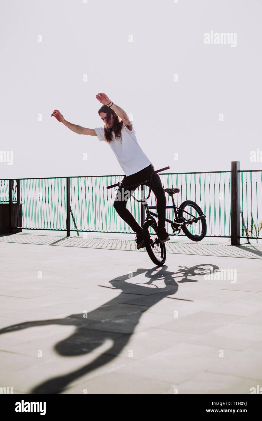 A young man doing a trick without hands in his bmx bike Stock Photo