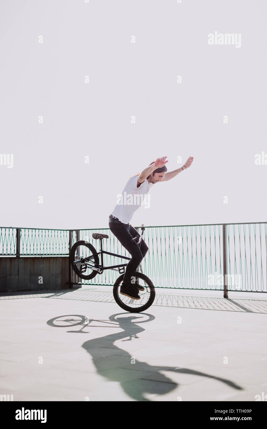 A young man doing a no hands trick in his bmx bike Stock Photo
