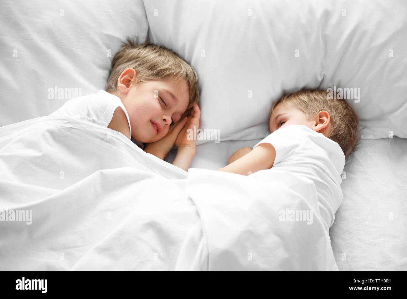 Cute boys sleeping in bed under blanket, closeup Stock Photo Alamy