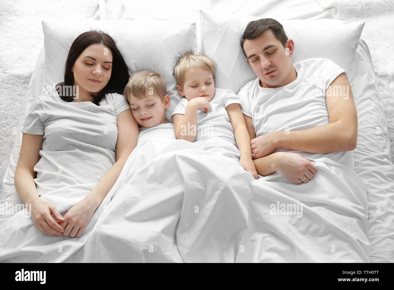 Family sleeping in bed under blanket, closeup Stock Photo Alamy