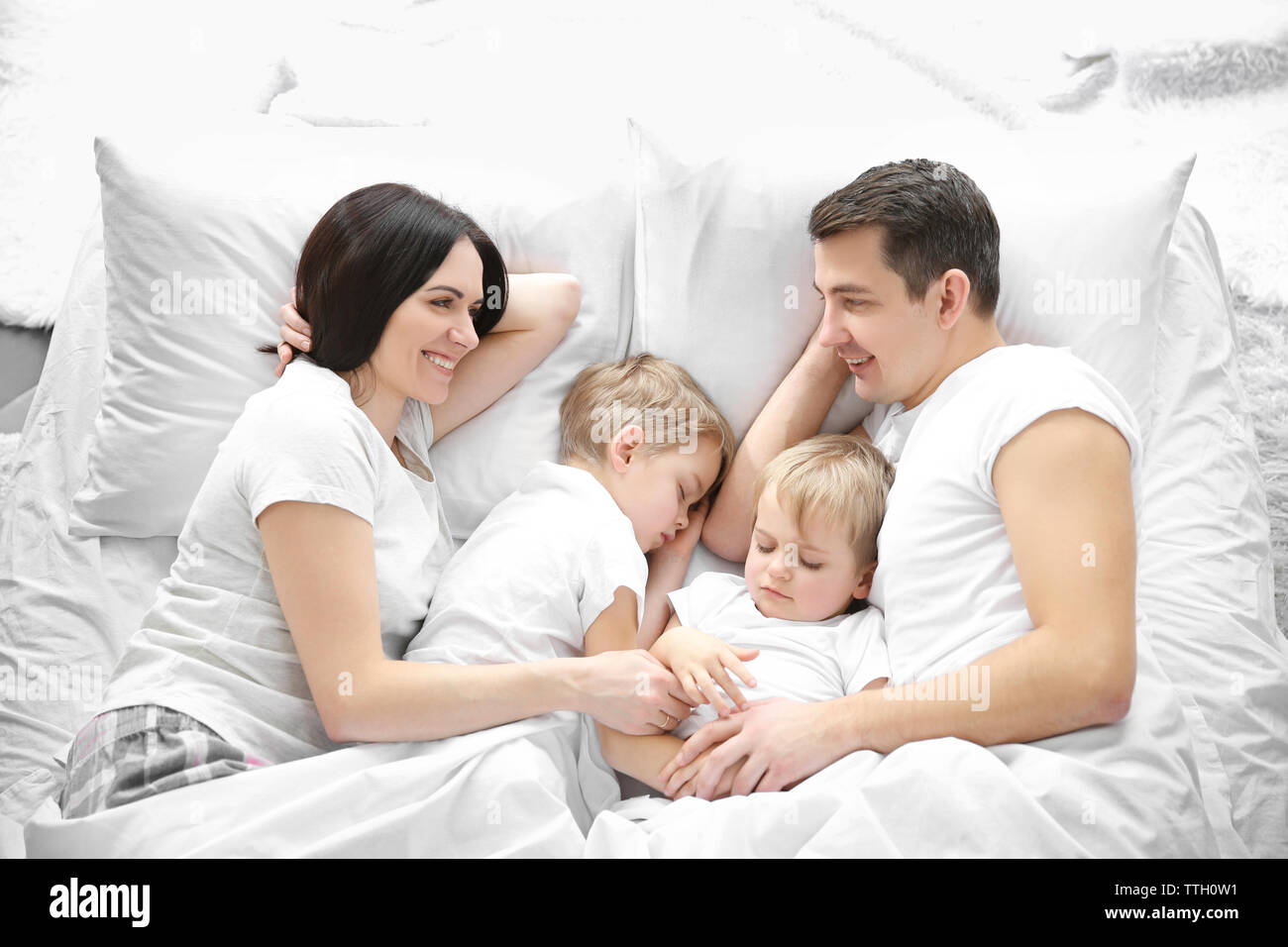 Family smiling in bed under blanket, closeup Stock Photo Alamy