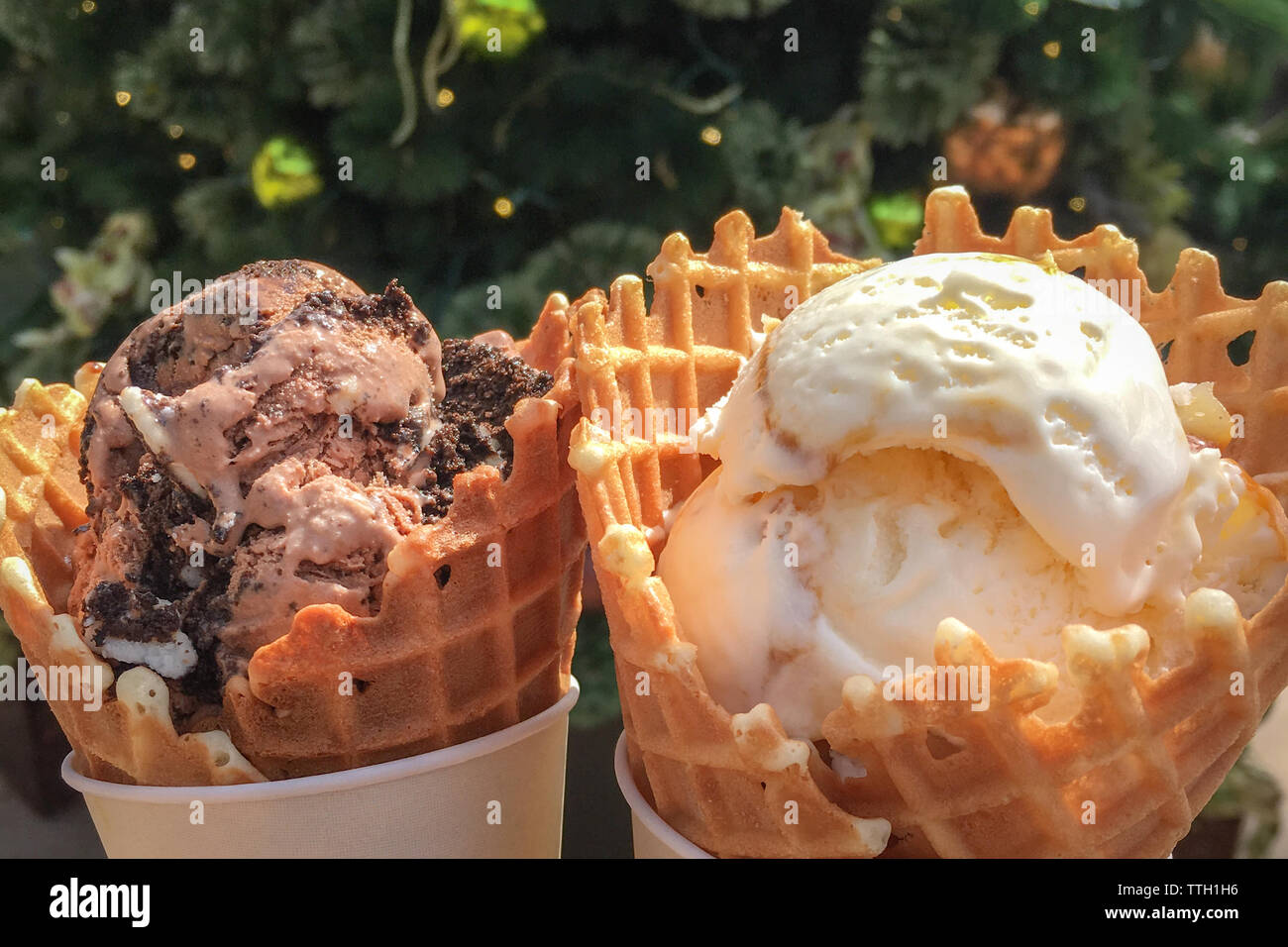 A brown and a white scoops of ice cream, each in a cone Stock Photo