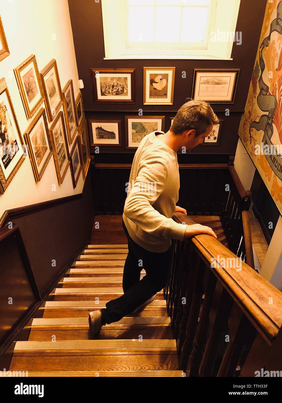 Man walking down a stair with the walls full of retreats Stock Photo