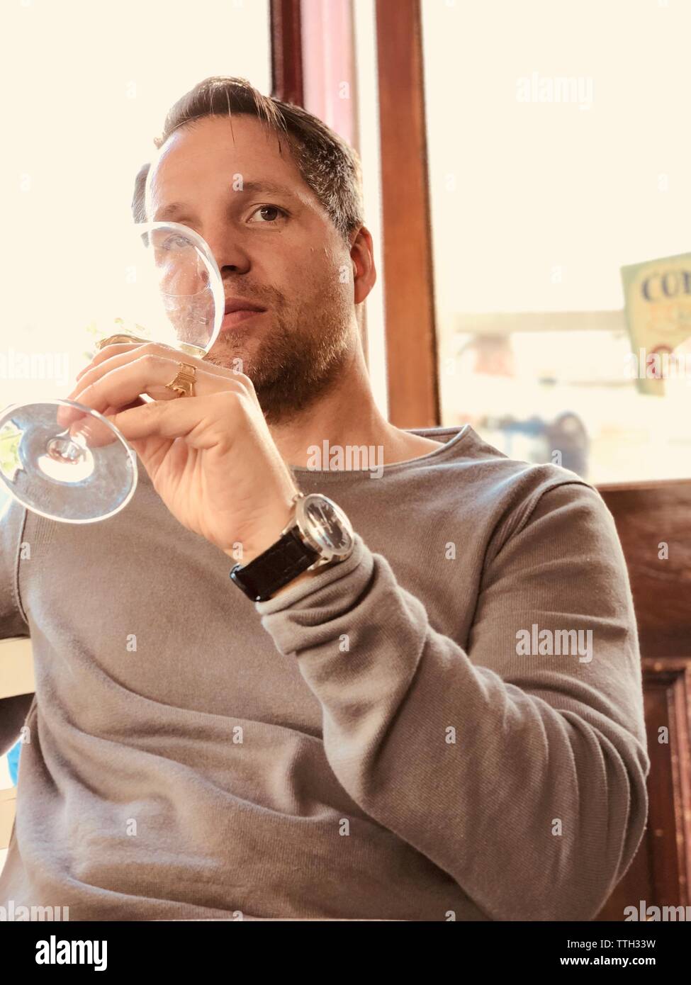 Man taking a glass of white wine with a seriously face Stock Photo