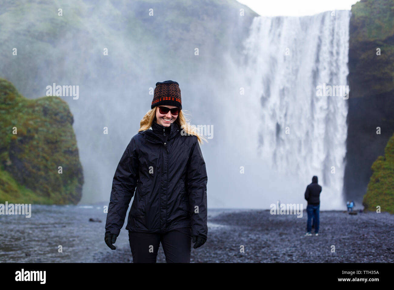 Millenial Female Traveler in Skogafoss, Iceland Stock Photo