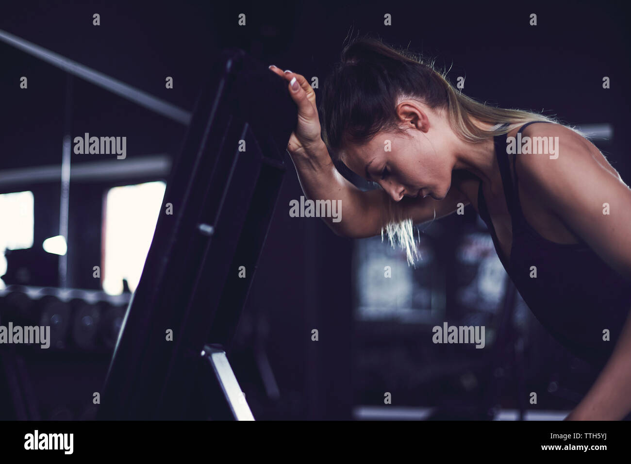 Young woman resting at fitness centre after exercise Stock Photo