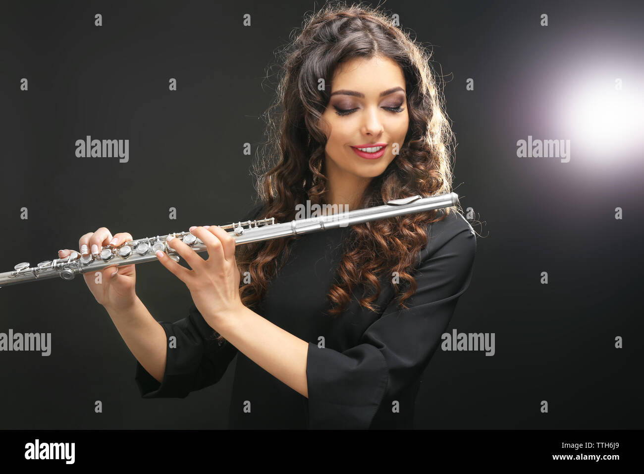Beautiful young woman with flute on dark background Stock Photo - Alamy