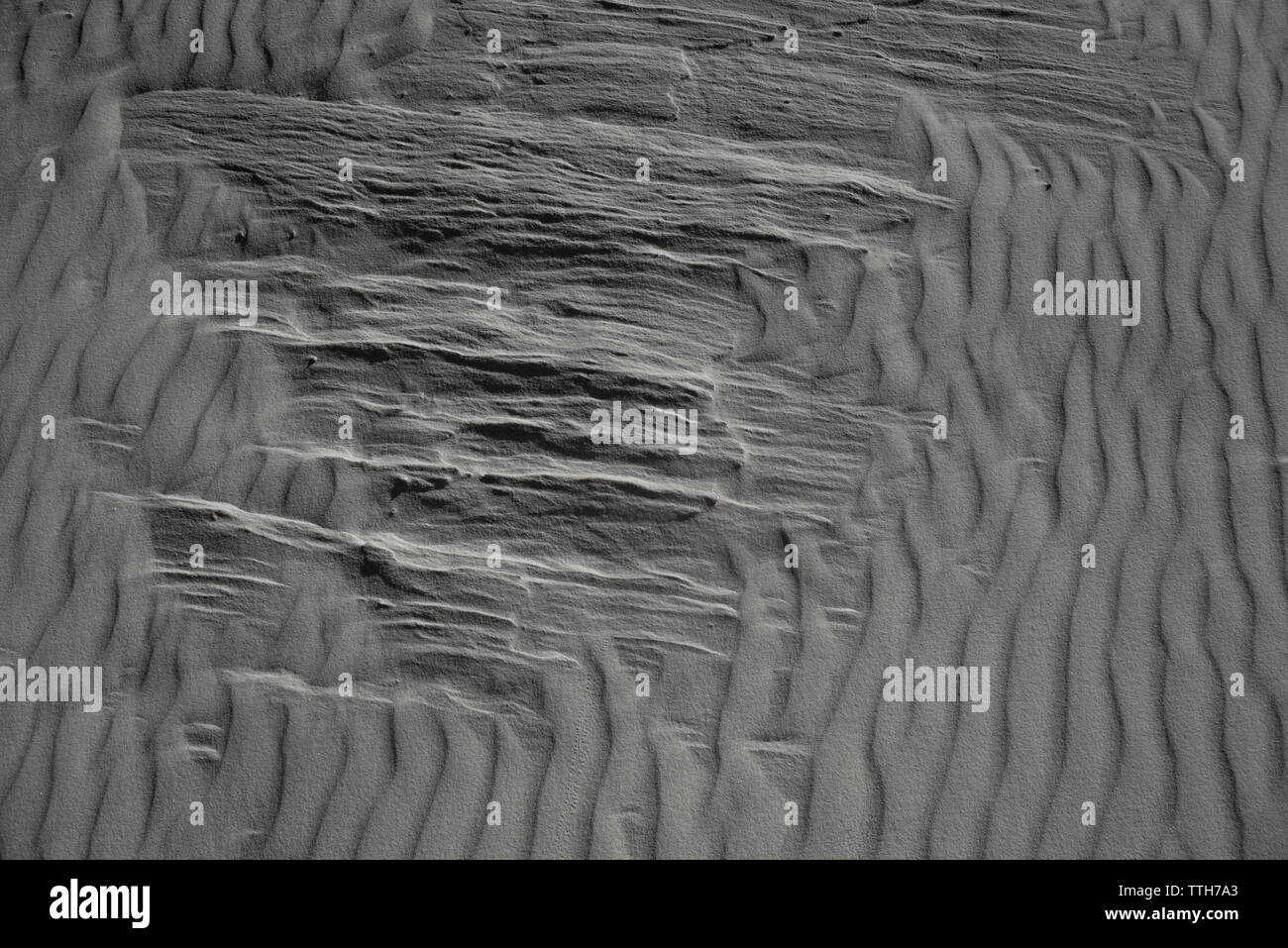 Close-up of sand dune striation pattern broken by hard sediment Stock Photo