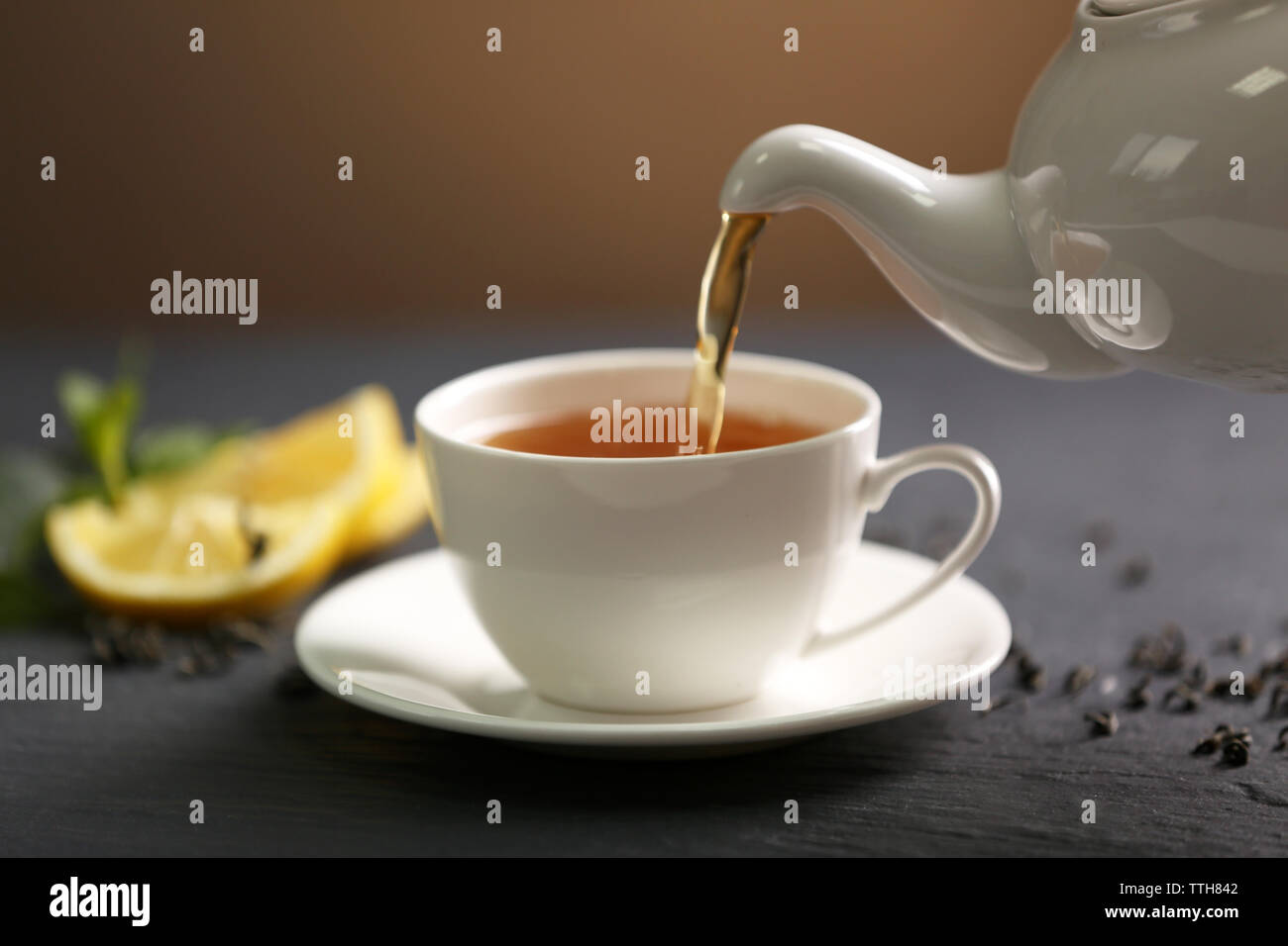 Teapot pouring tea in cup Stock Photo Alamy