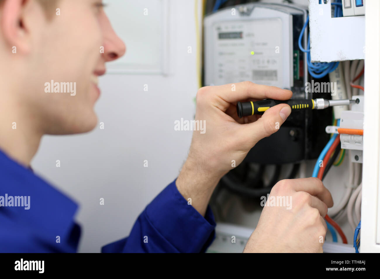 Young electrician working with screwdriver in fuse board Stock Photo Alamy