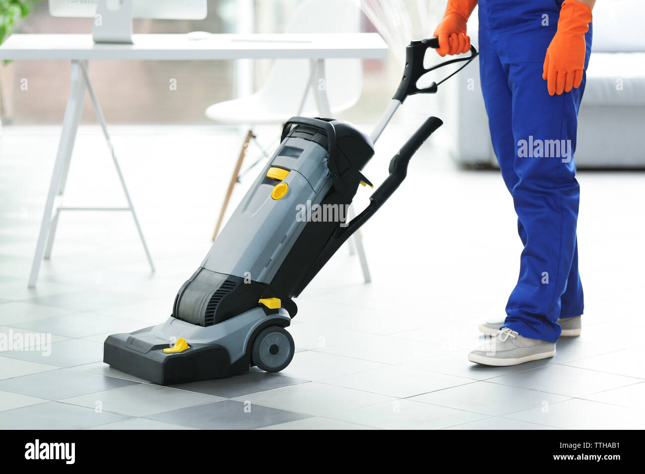 Young Janitor With Washing Machine Cleaning Floor In Office Stock