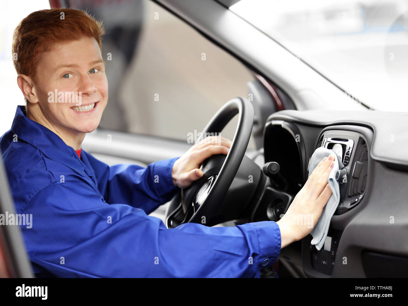 Young man polishing vehicle interior Stock Photo