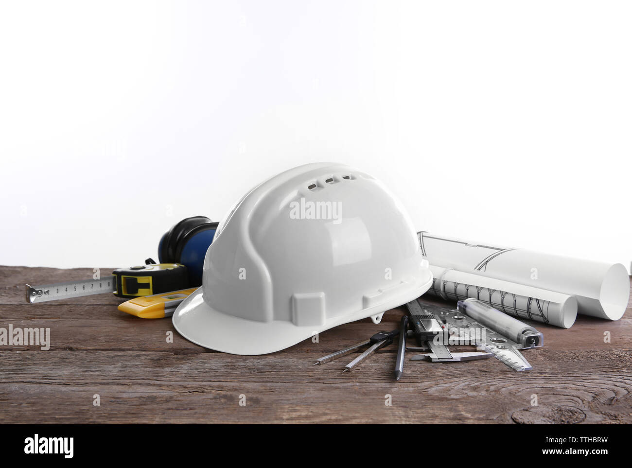 Yellow helmet and blueprints on a white background Stock Photo - Alamy