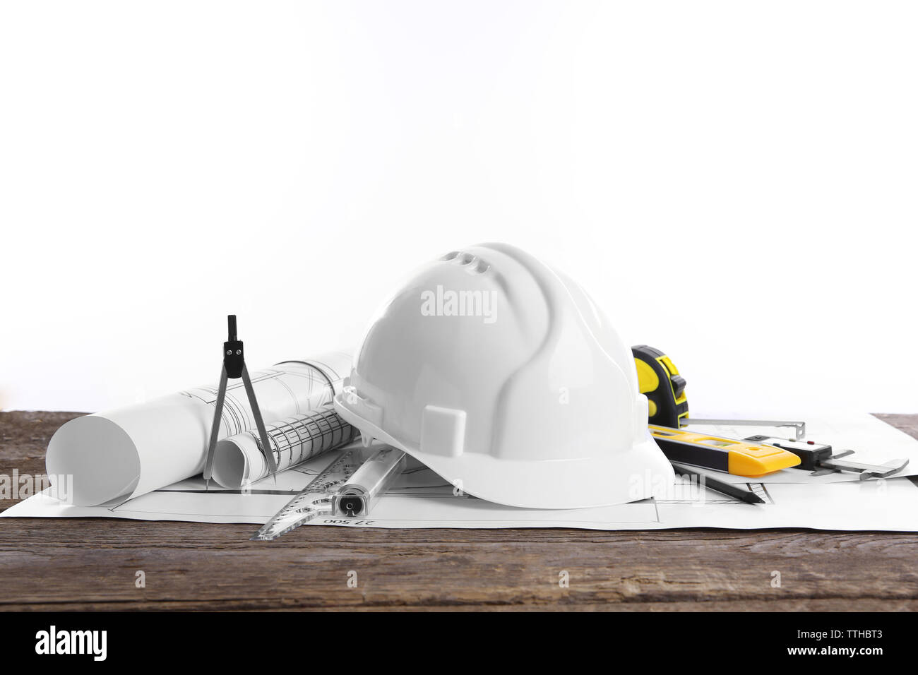 Yellow helmet and blueprints on a white background Stock Photo - Alamy