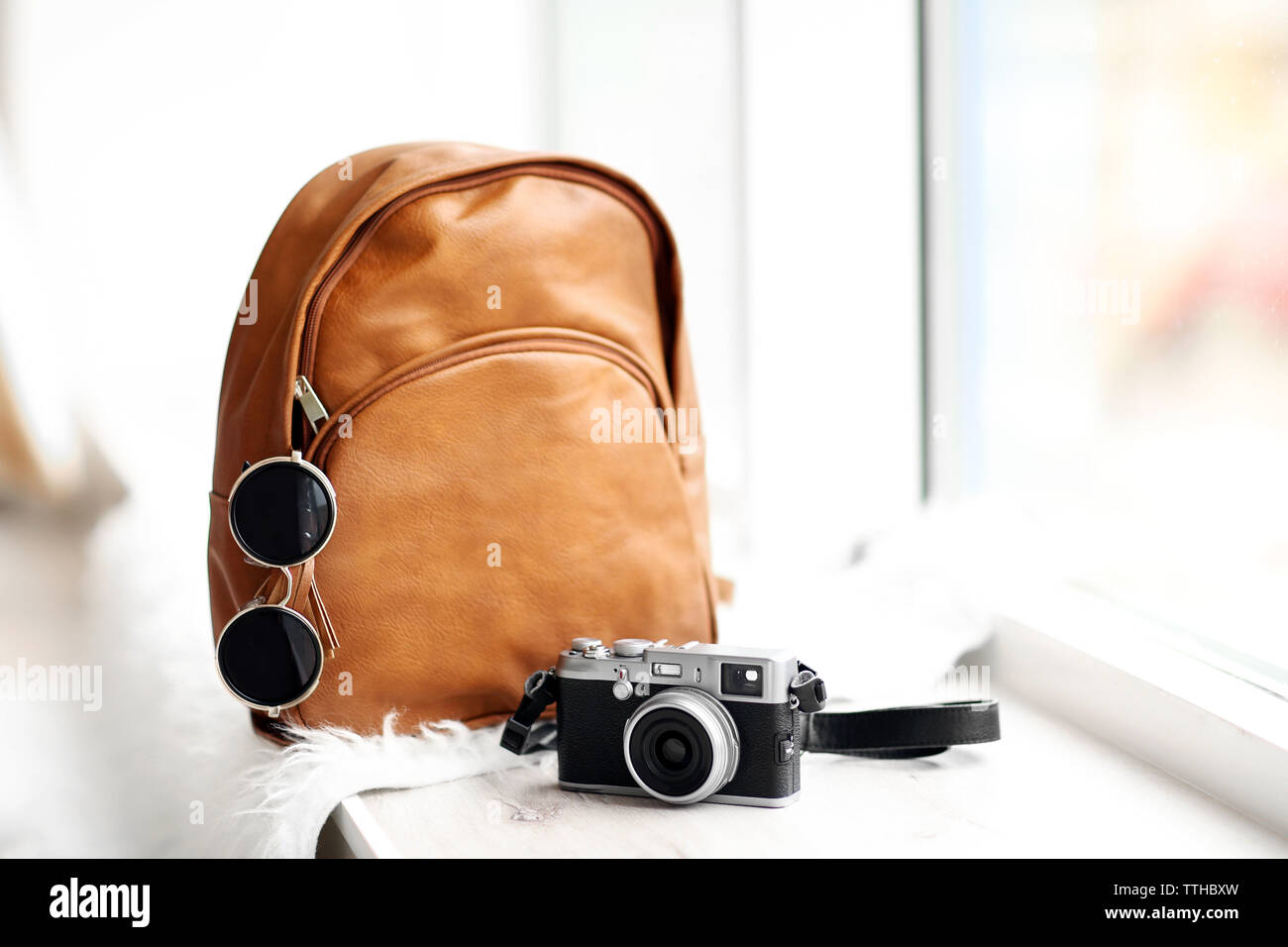 Brown leather backpack on the windowsill. Stock Photo