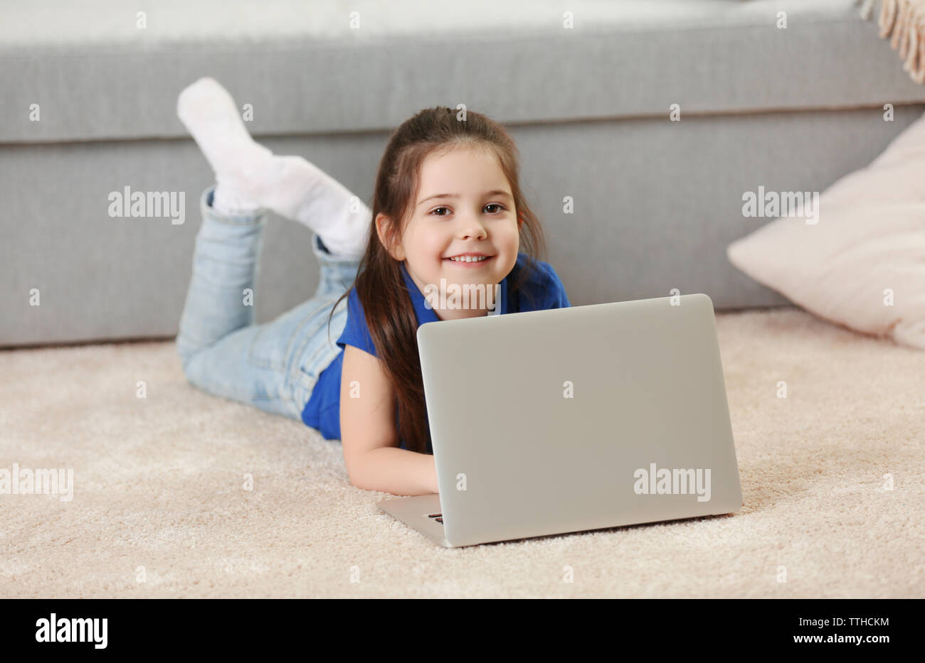 Little girl using laptop on floor indoors Stock Photo - Alamy