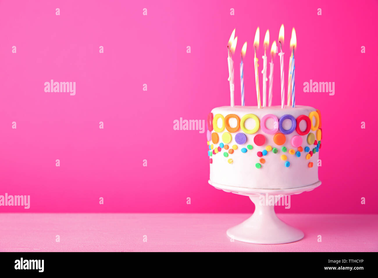 Birthday cake with candles on pink background Stock Photo - Alamy