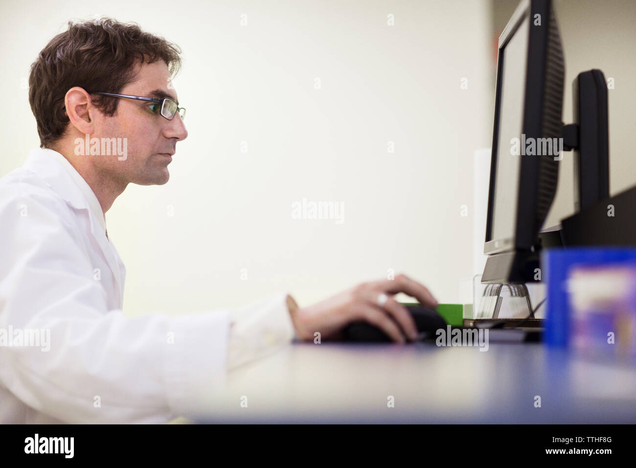 Side view of dentist using computer at clinic Stock Photo