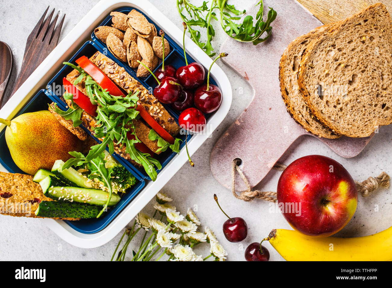 Cooking a healthy meal in a lunch box. Sandwich, fruit, snacks on a