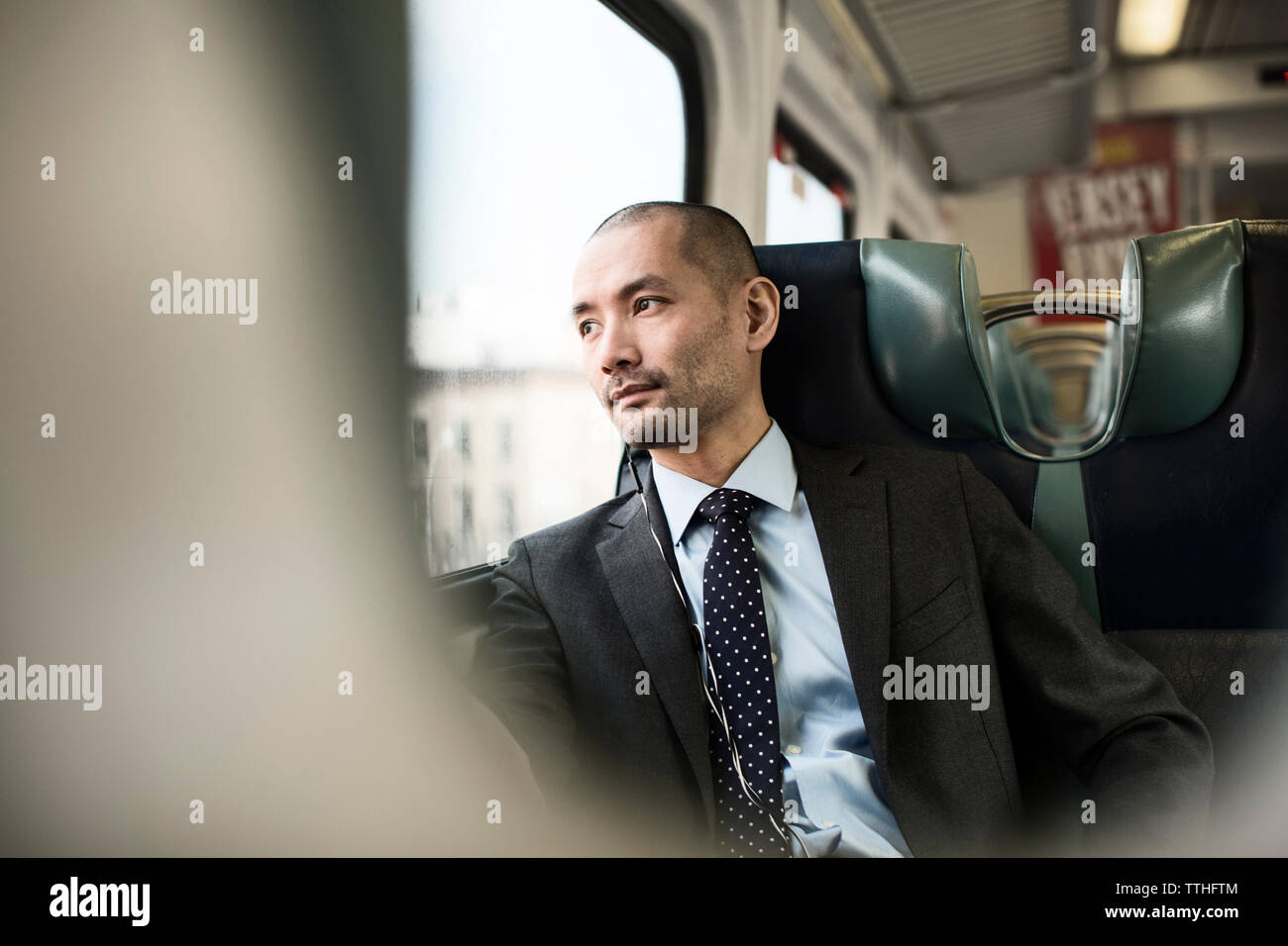 Thoughtful businessman traveling in train Stock Photo