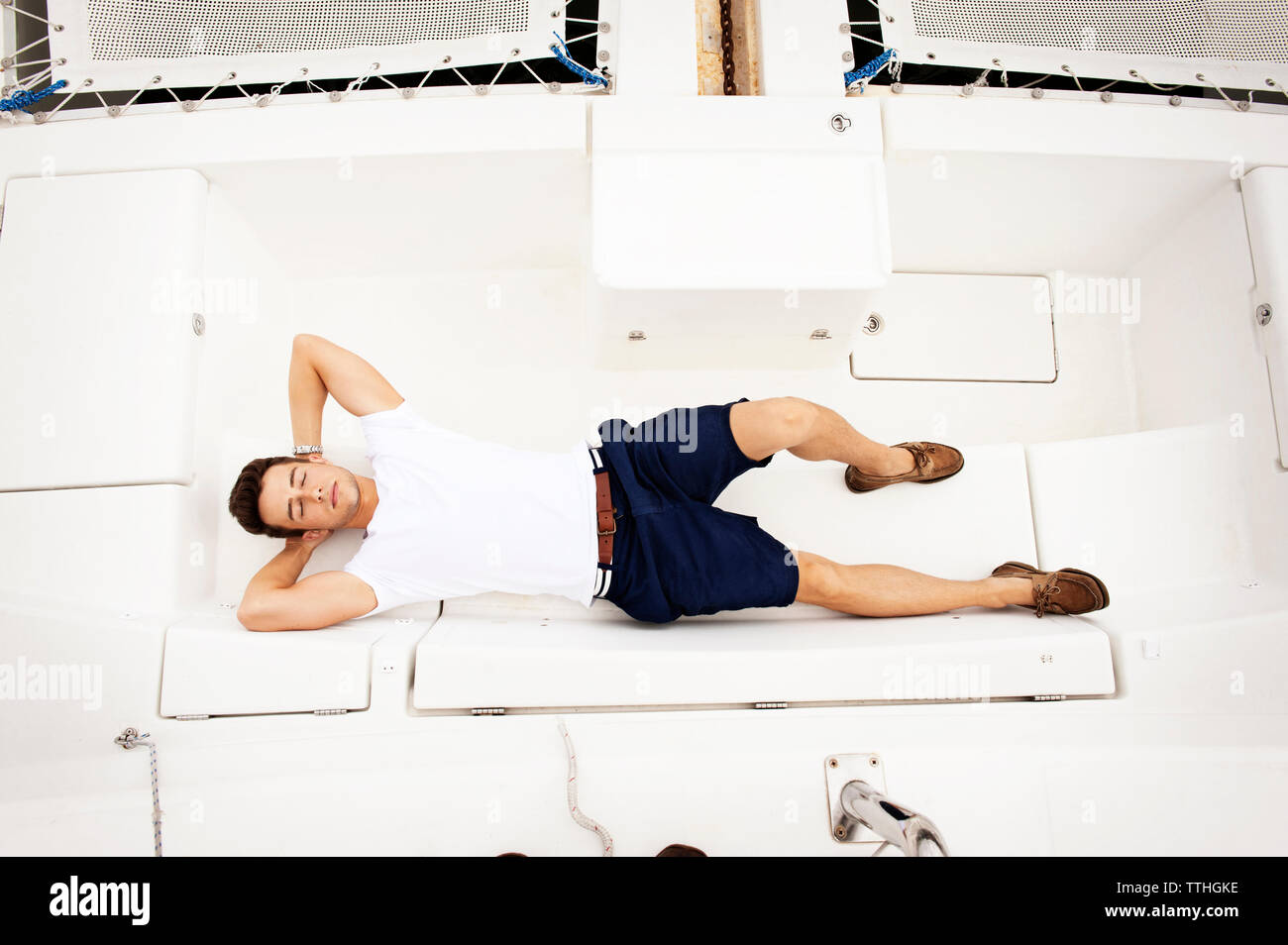 Overhead view of handsome man relaxing on sailboat Stock Photo