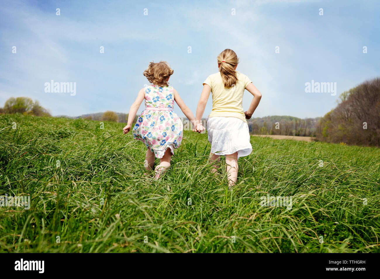 Two girls running holding hands hi-res stock photography and images - Alamy