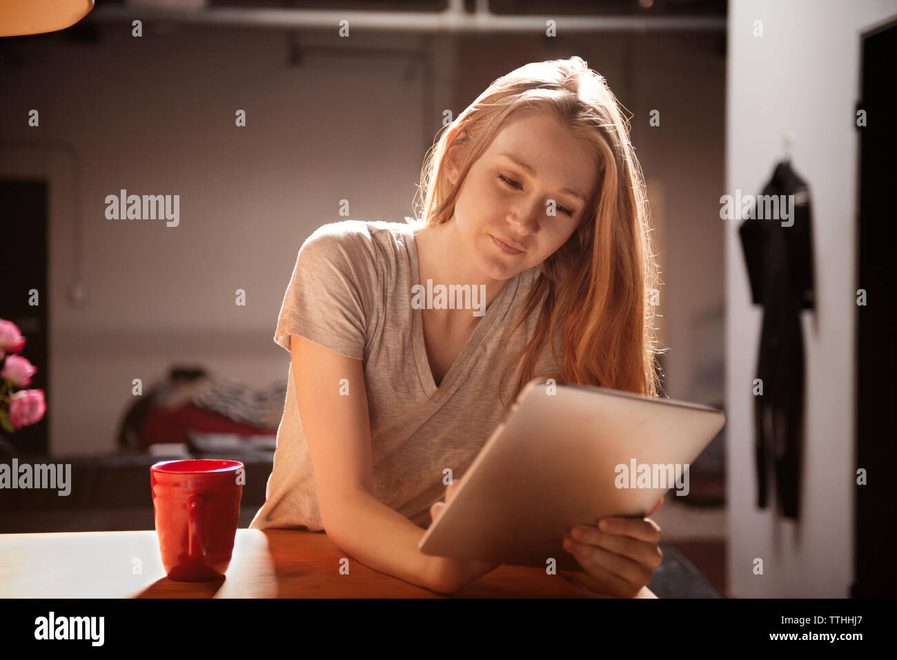 Young woman using tablet pc in kitchen Stock Photo