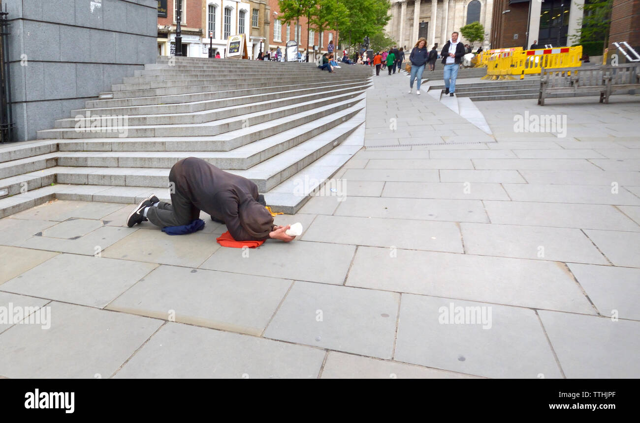 London, England, UK. Homeless man begging in Peters Hill, within sight of St Paul's Cathedral Stock Photo