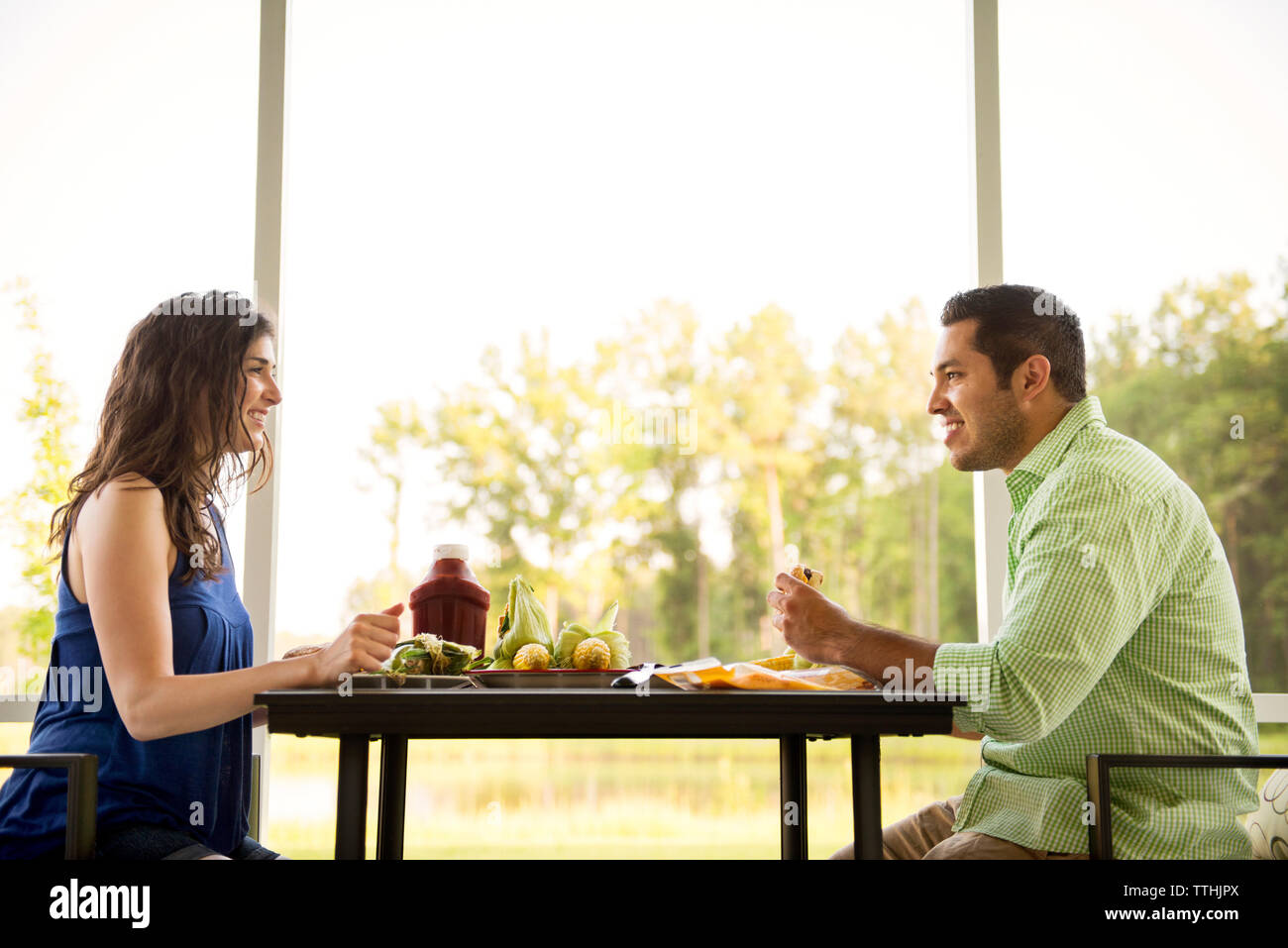 Side view of couple having discussion while eating food at table Stock Photo